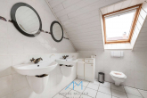 DG Badezimmer1.1 - Beeindruckende Raumhöhe und optionale Einliegerwohnung. Stilvolles Architektenhaus in Grolsheim.
